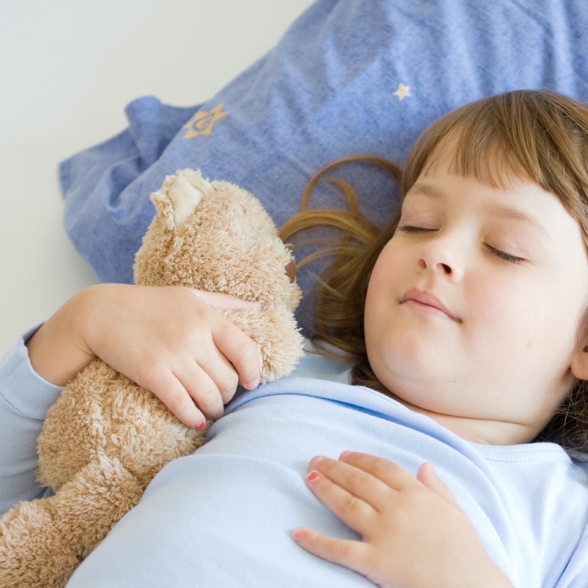 cute little girl sleeping on a blue pillow