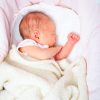 Newborn baby girl sleeping in a bassinette